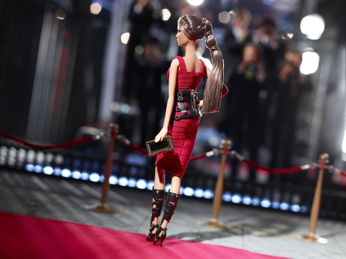 The Hervé Léger by Max Azria Barbie wears a scarlet bandage dress 