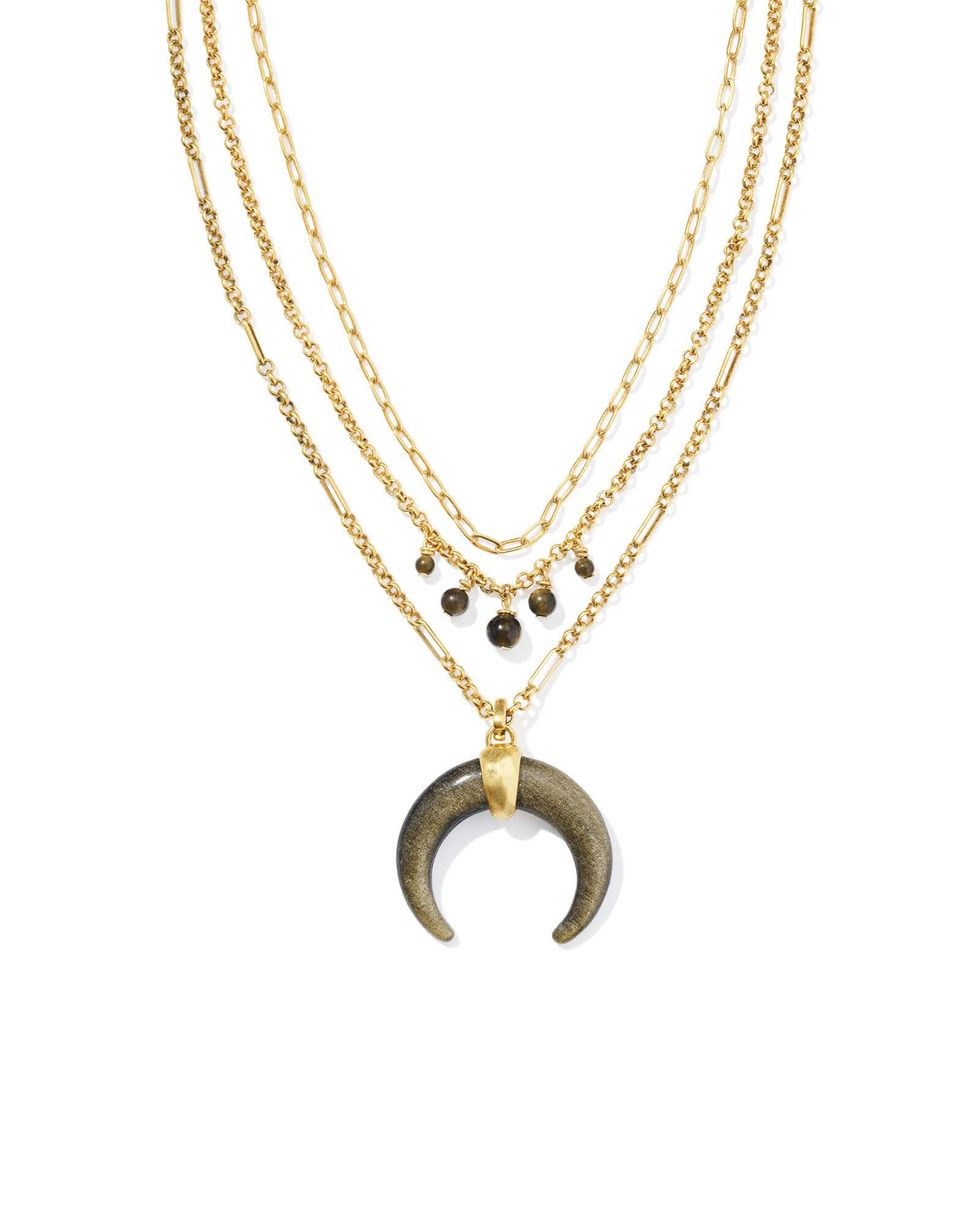 A multi-strand gold necklace with a moon shaped pendant, from the Yellow Rose x Kendra Scott by Lainey Wilson collection