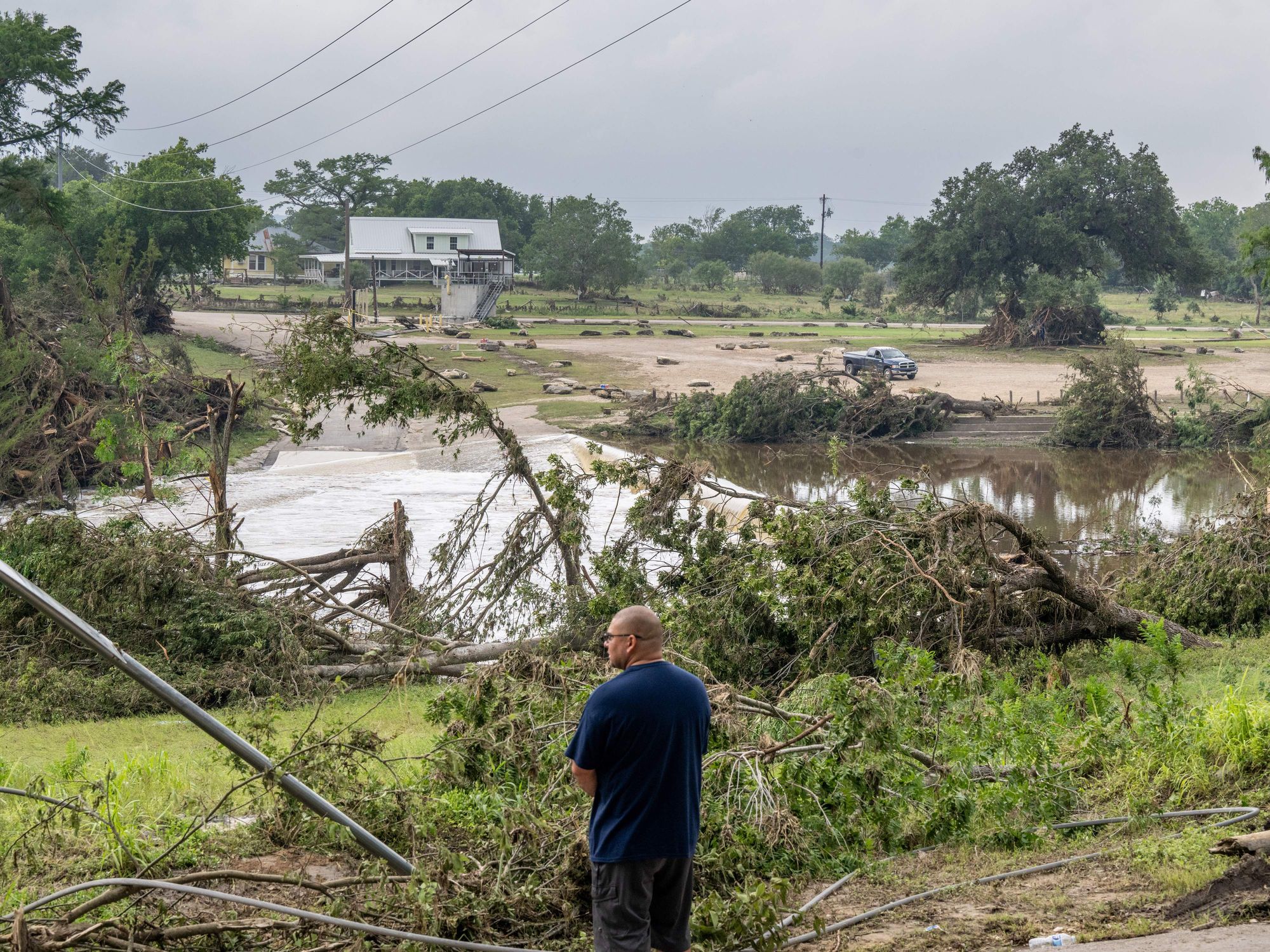 A person overlooks the banks of the Guadalupe River on July 06, 2025