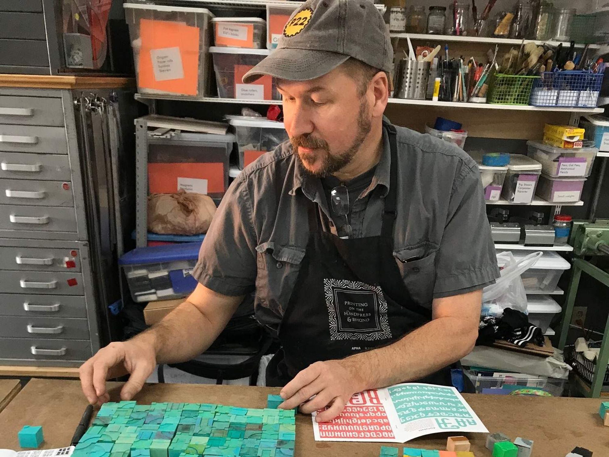 A person using stamps to make a book at the Austin Book Arts Center