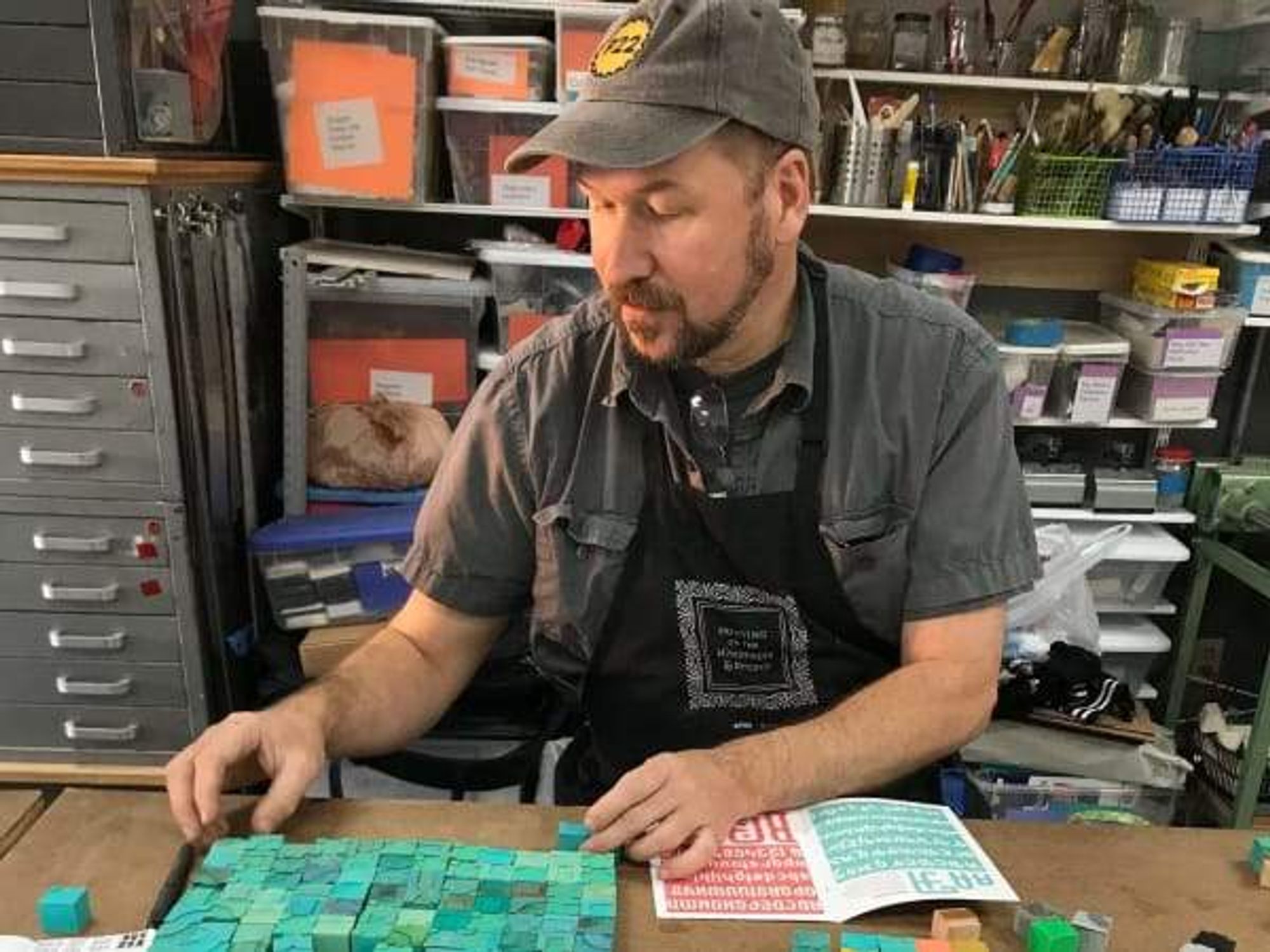 A person using stamps to make a book at the Austin Book Arts Center