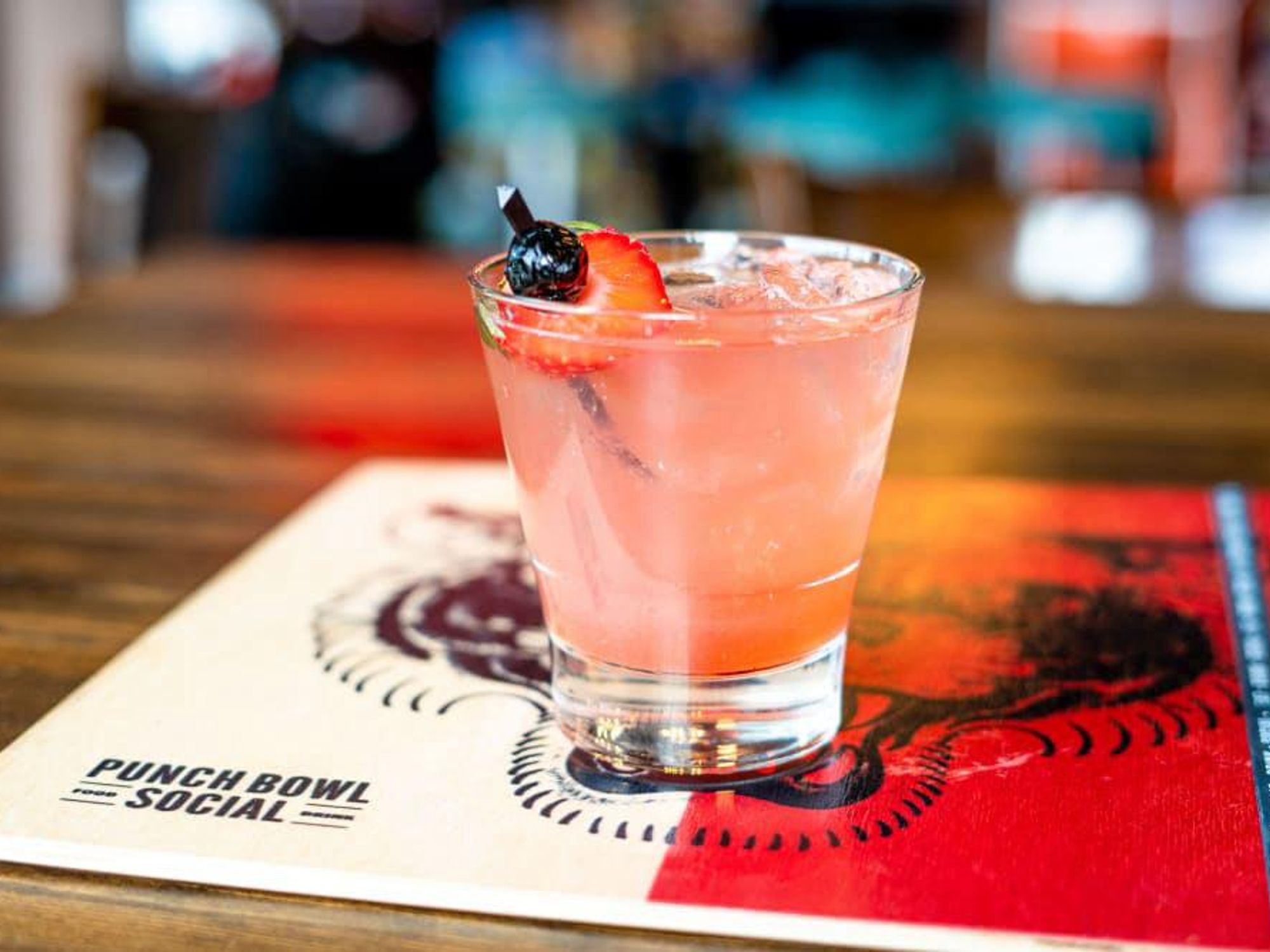 A pink punch with a strawberry garnish by Punch Bowl Social.