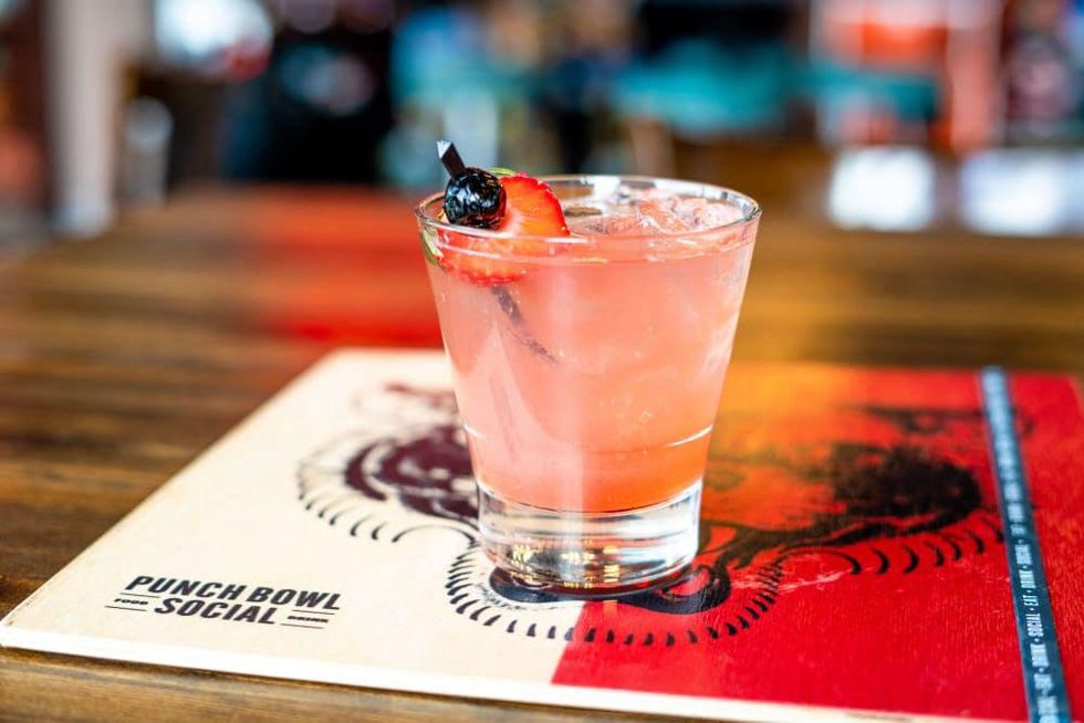 A pink punch with a strawberry garnish by Punch Bowl Social.