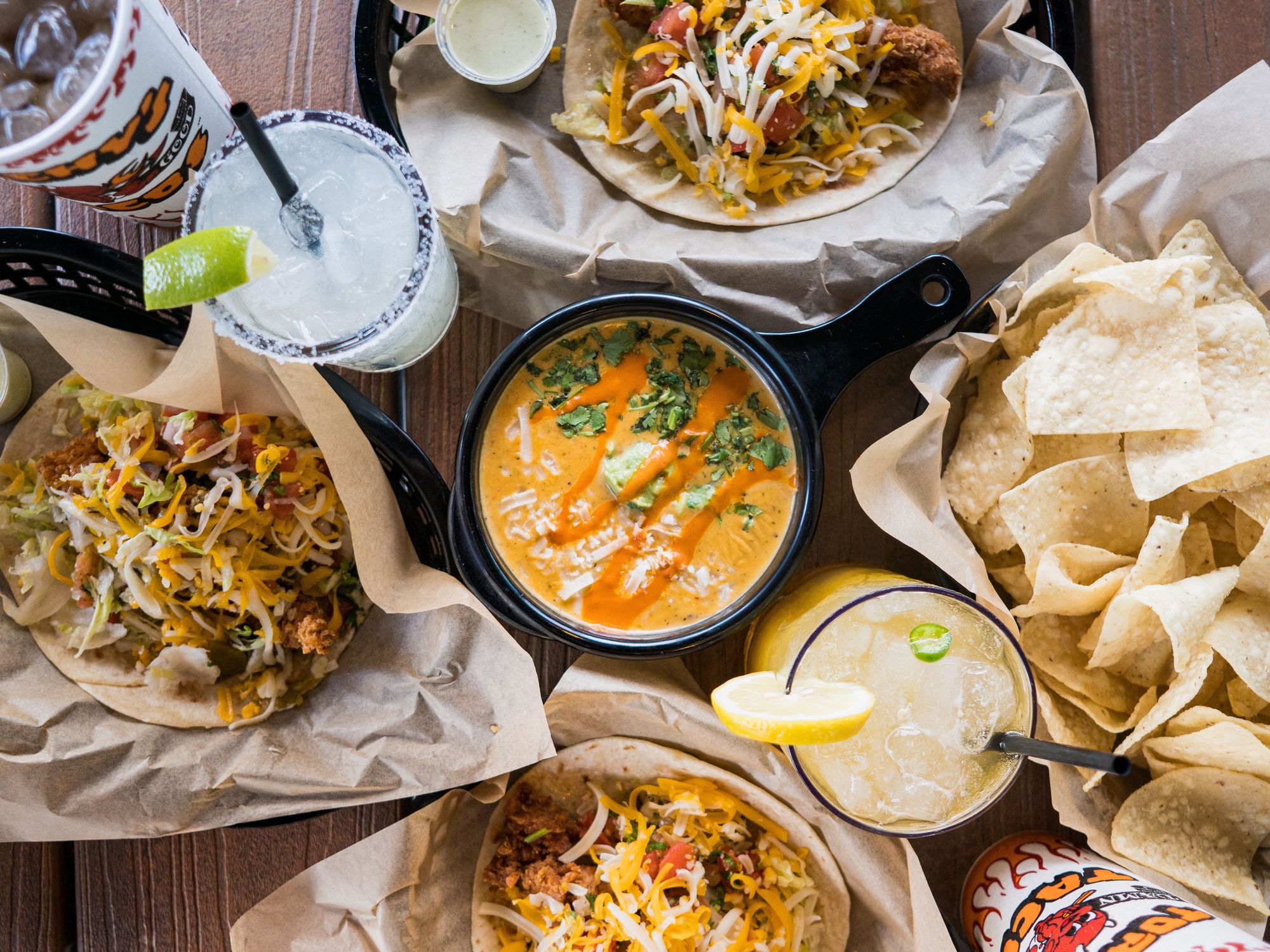 A spread of tacos, queso and beverages at Torchy's Tacos.