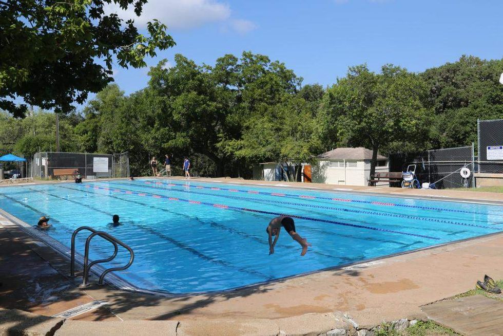A swimmer dives into the deep end at Big Stacy Pool in Travis Heights.
