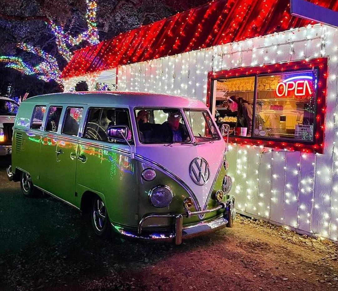 A VW bus drives through a holiday-decorated drive-thru.