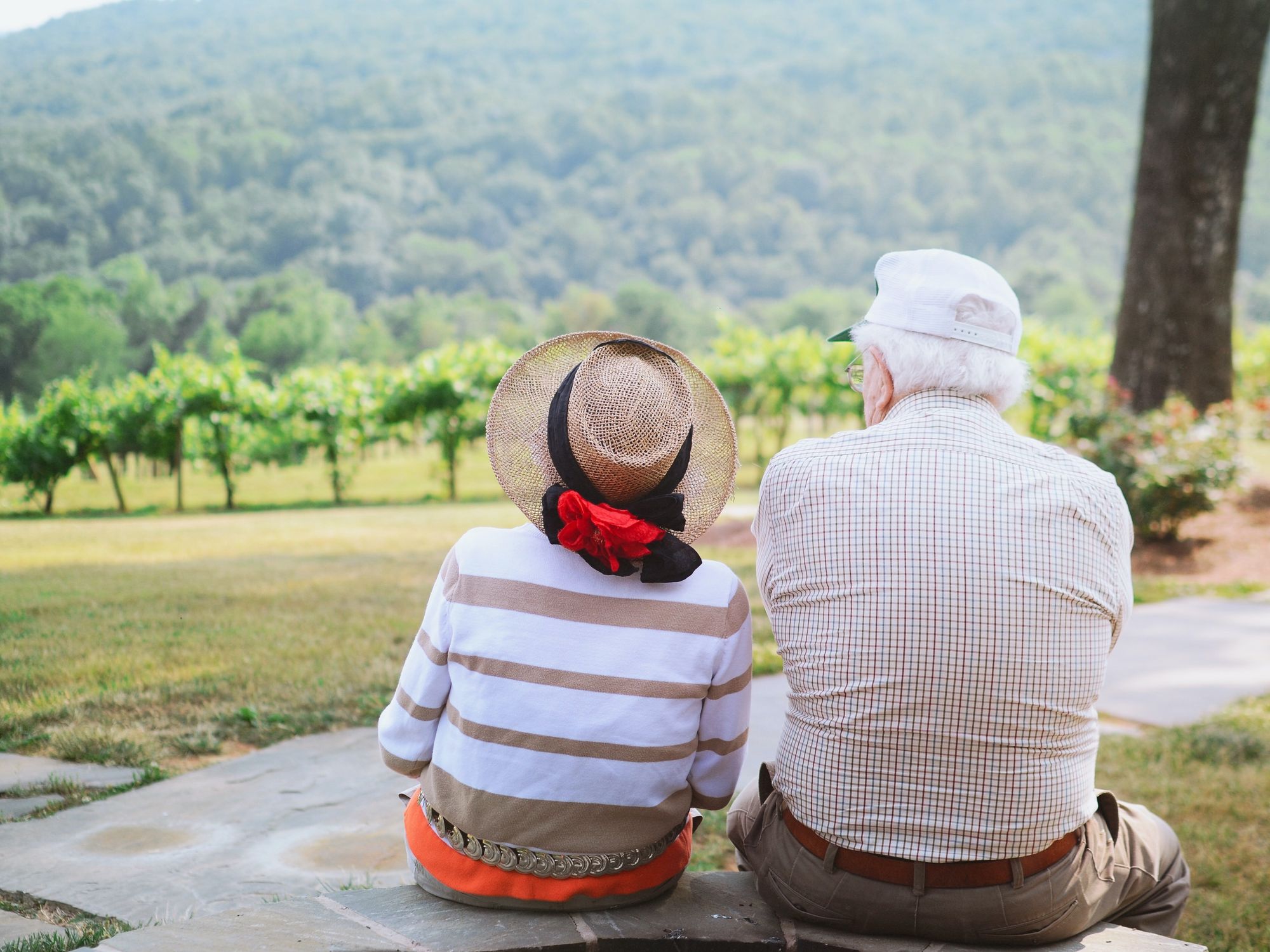An elderly couple enjoying their backyard view of a hillside
