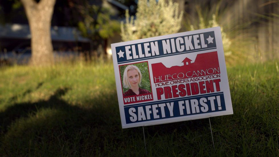 An "Ellen Nickel for HOA President" sign in somebody's lawn.