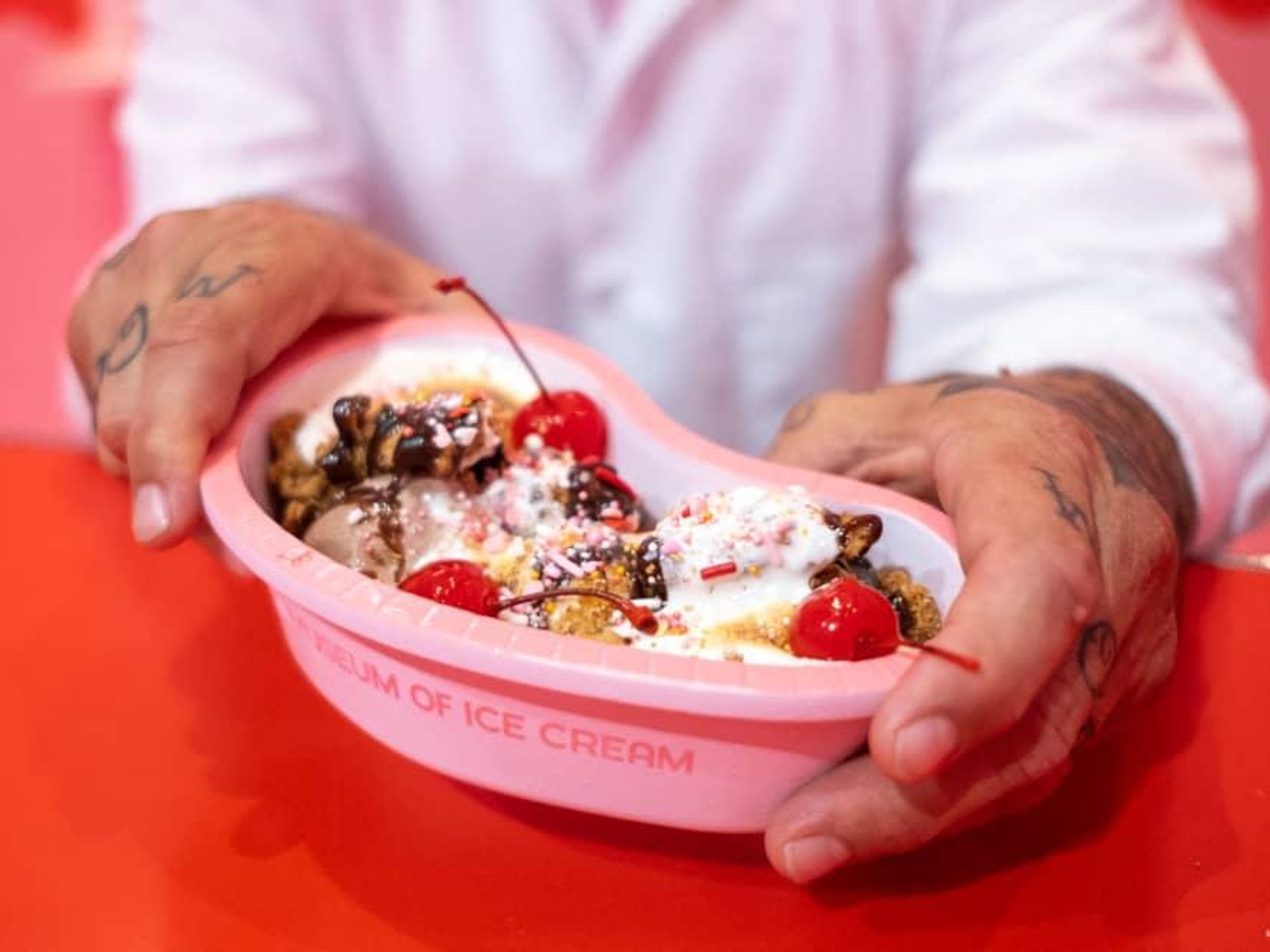 An ice cream sundae with chocolate and vanilla ice cream, toasted meringue, graham cracker crumble, and smoked cherries.