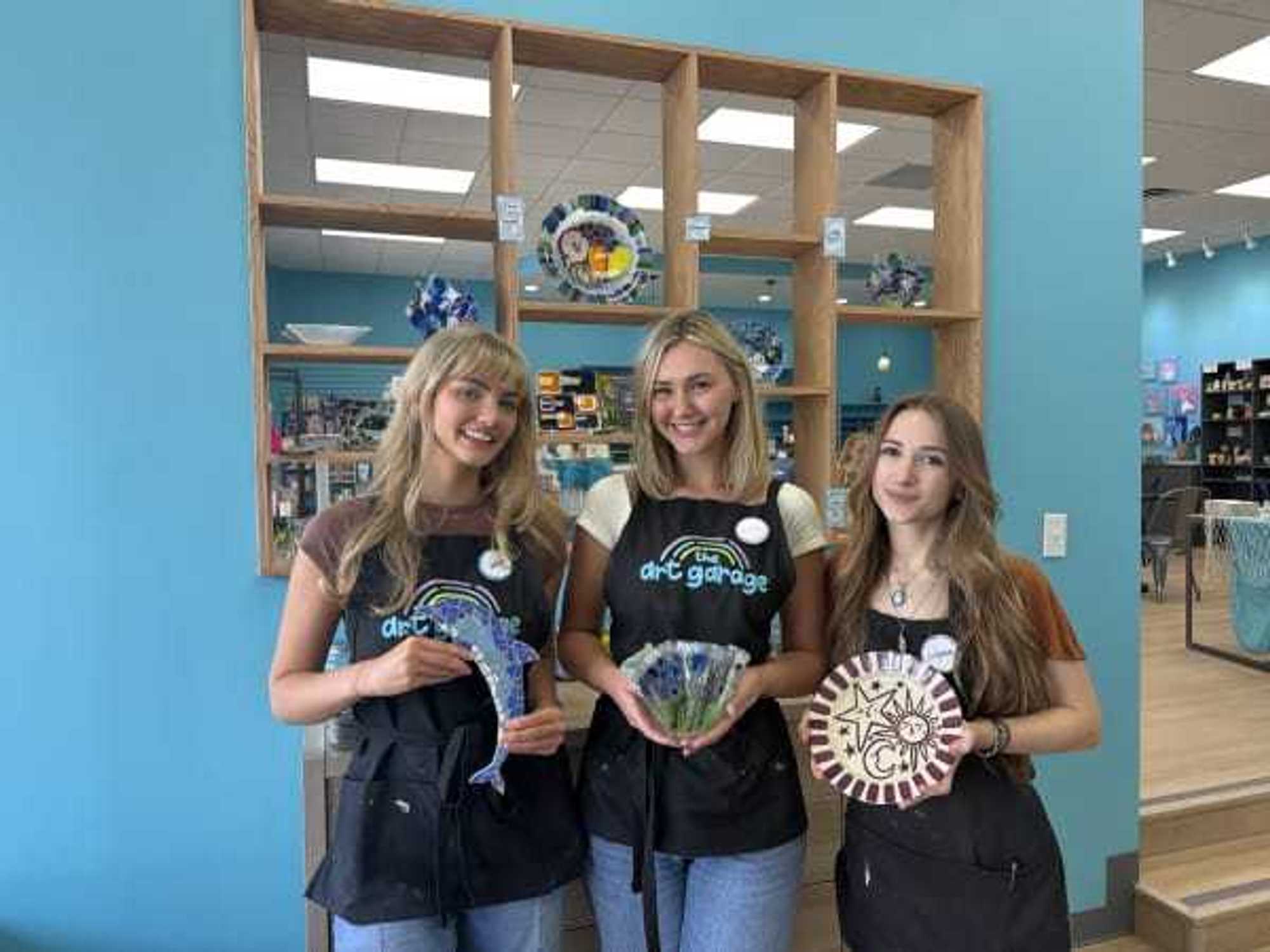 Art Garge staff holding crafts in different media