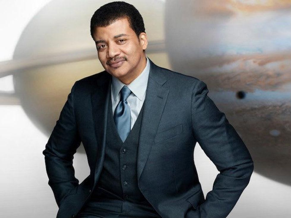 astrophysicist and scientist Neil deGrasse Tyson in front of planets