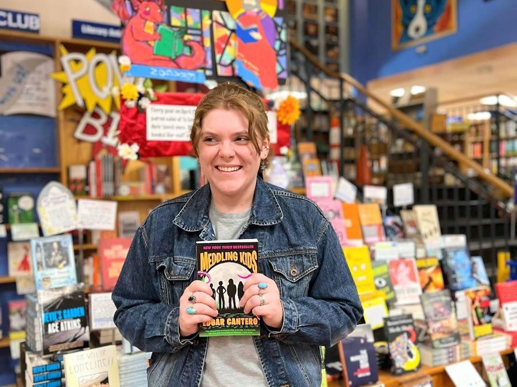 BookPeople interior, graphic designer holding book.