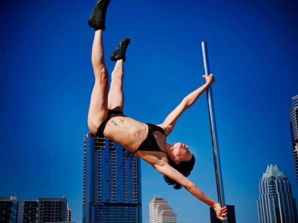 Brass Ovaries pole dancer performing in front of Downtown Austin skyline