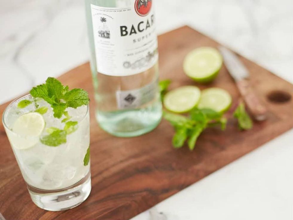 Cocktail and bottle of Bacardi on a cutting board