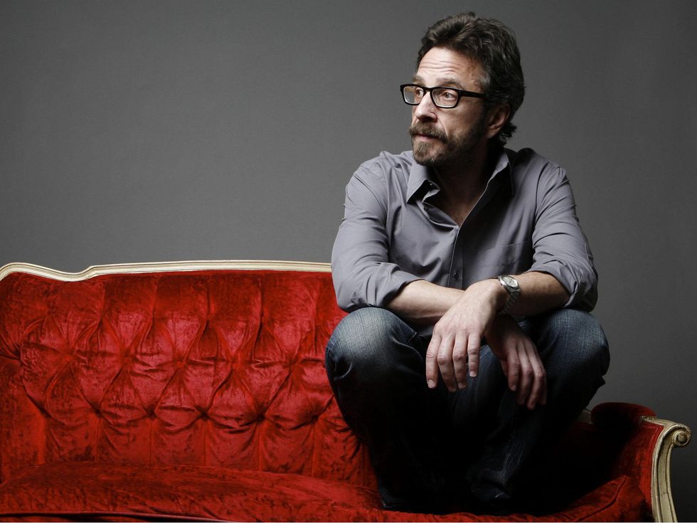 comedian Marc Maron sitting on a couch