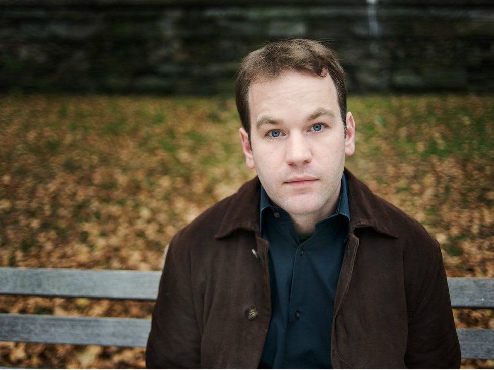 Comedian Mike Birbiglia headshot sitting on park bench