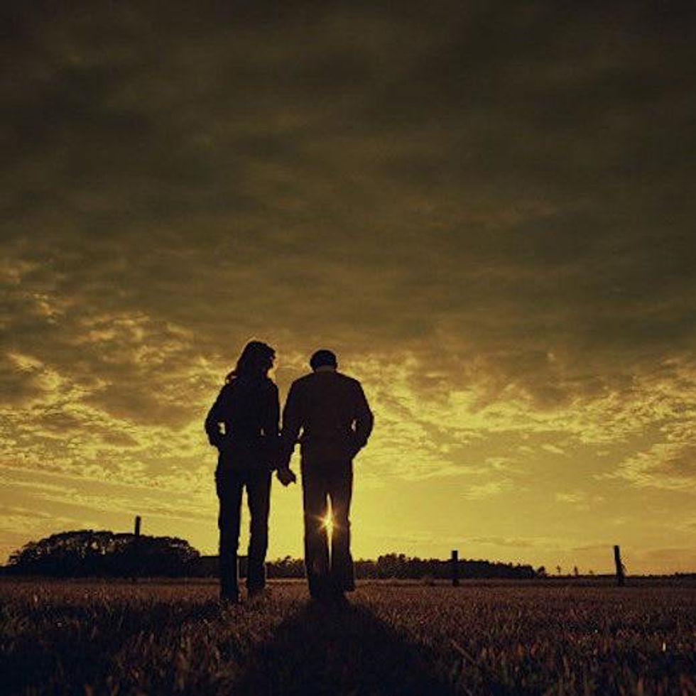 couple walking holding hands in a field