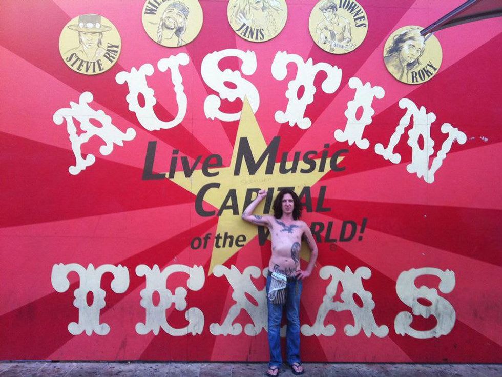 cropped Mickey Avalon shirtless in front of Austin mural