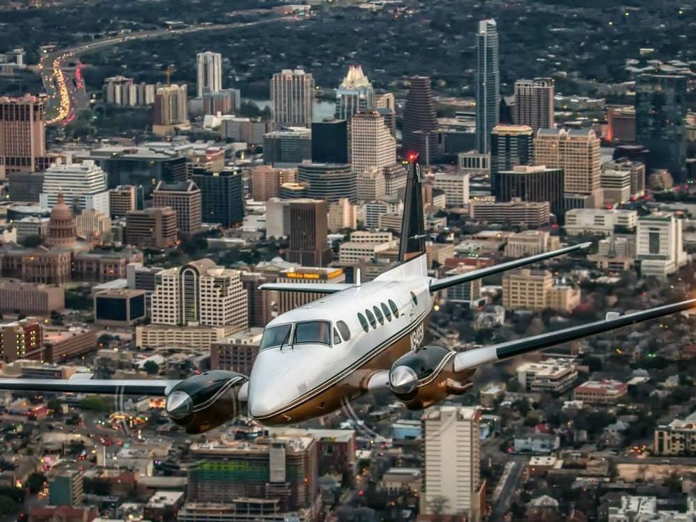 Envi Airways plane jet Austin downtown skyline