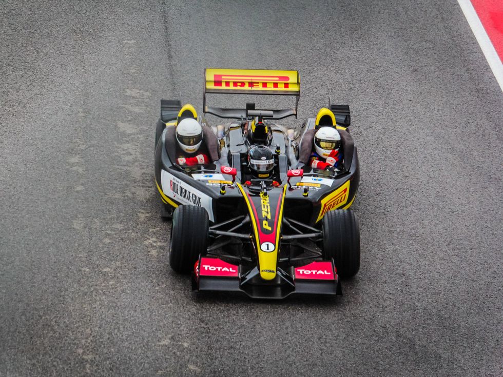 Formula 1 ride along overhead shot of black car for Ride Drive Give benefit