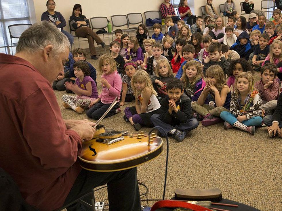 Fred Frith performing in front of school children