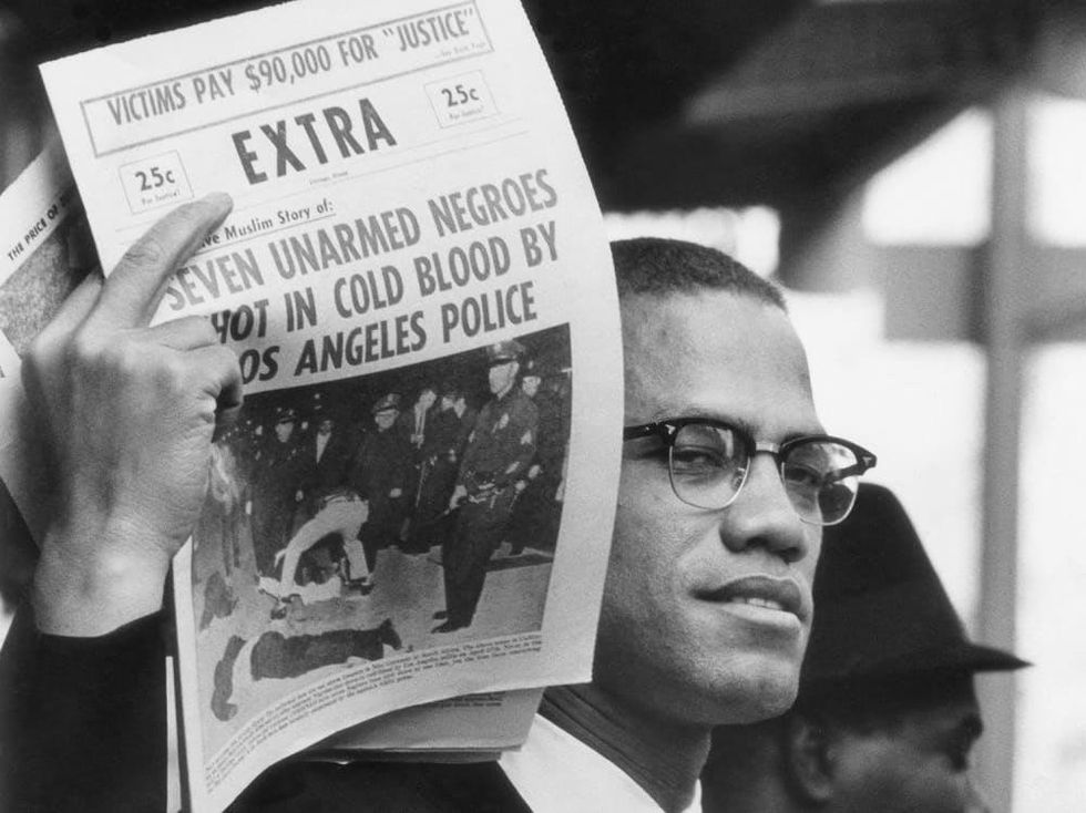 Gordon Parks Malcolm X Holding up Black Muslim Newspaper