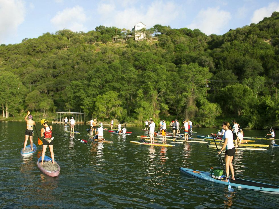 group of paddleboarders on lake austin for tyler's dam that cancer