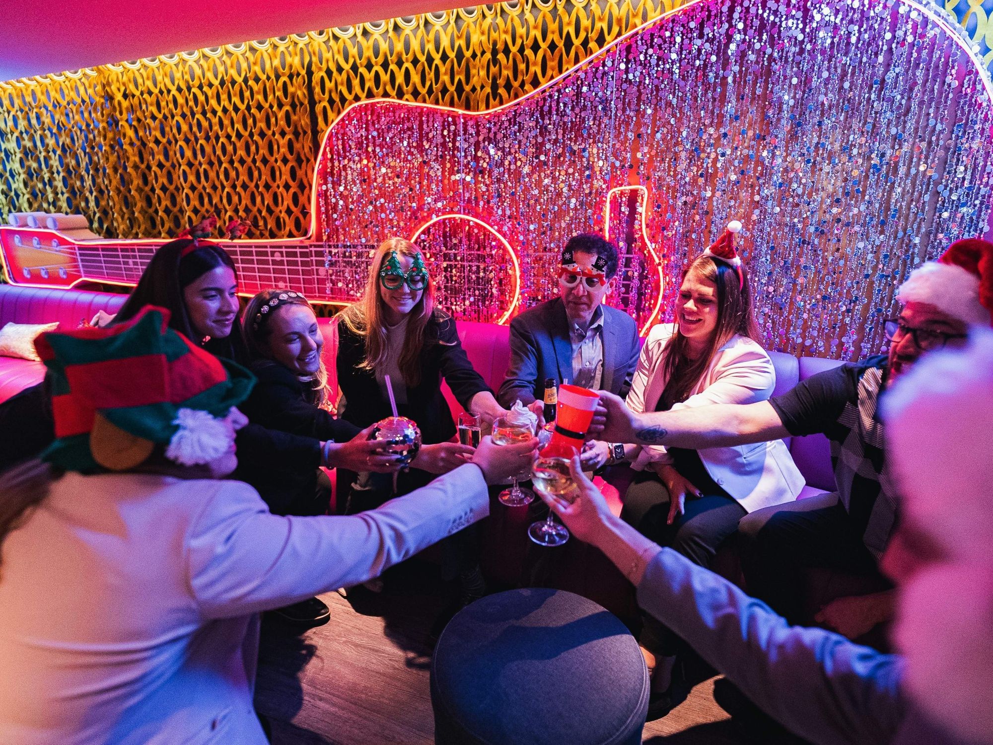 Guests adorned on holiday attire cheers in the Mr. Bo-Jingles Christmas-themed bar at the Hilton Austin.