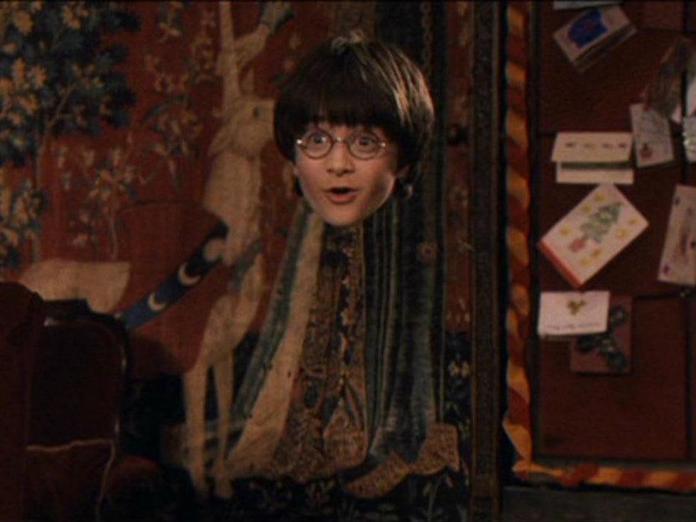 Harry Potter wearing invisibility cloak from the first movie