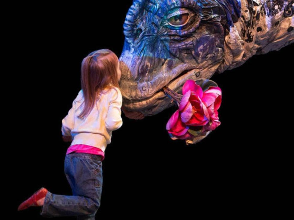 little girl kissing brachiosaurus at Erth's Dinosaur Petting Zoo