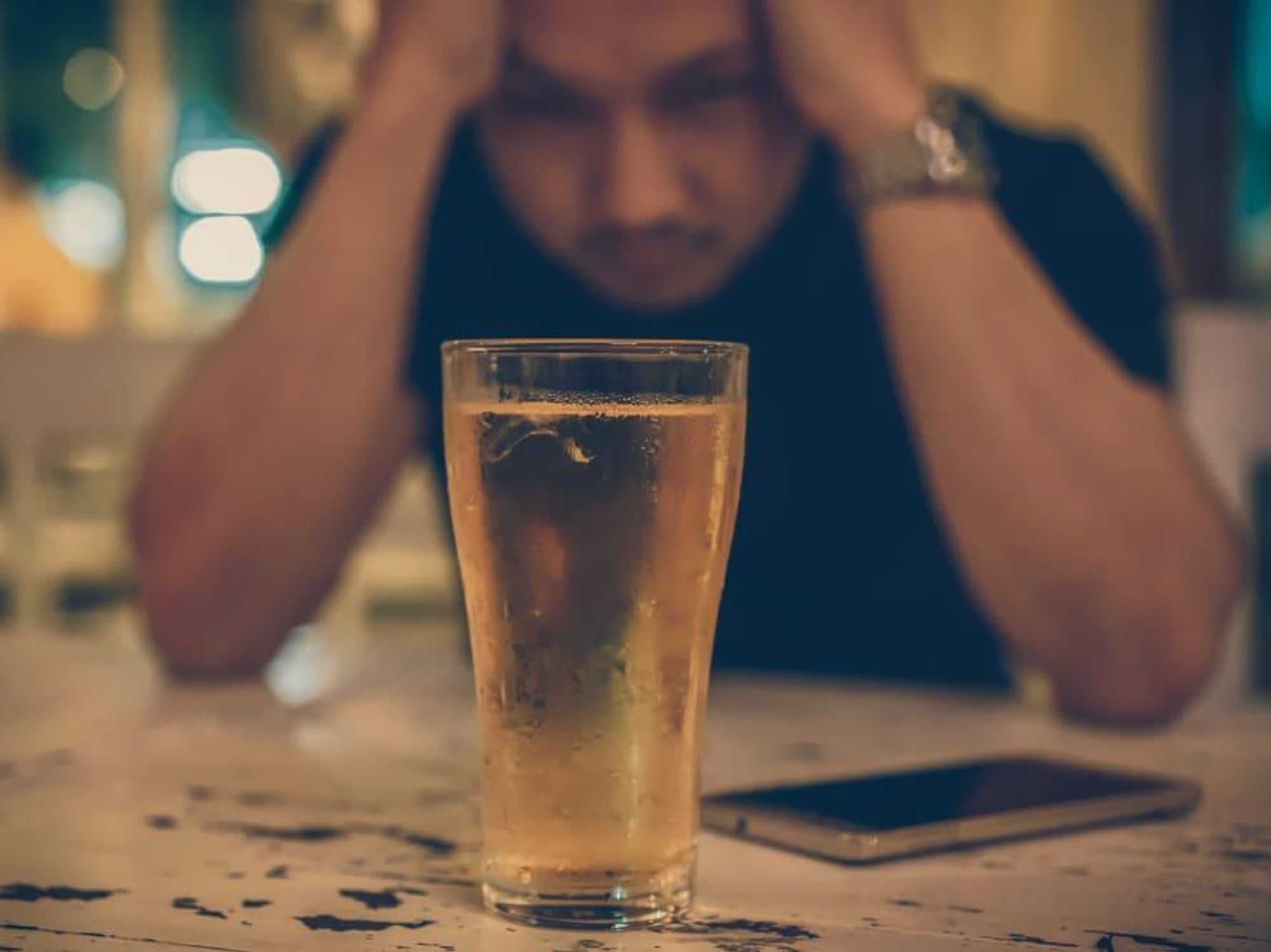Man alone at bar drinking beer