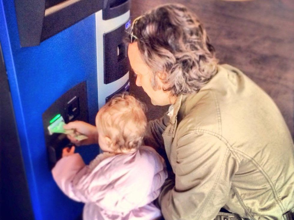 Man and a baby using Robocoin bitcoin ATM