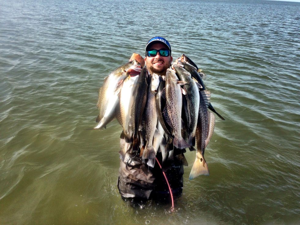 Man holding a lot of fish