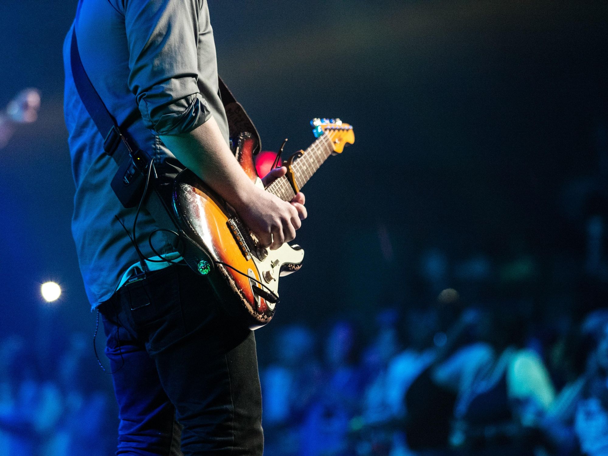 Man playing guitar at concert.