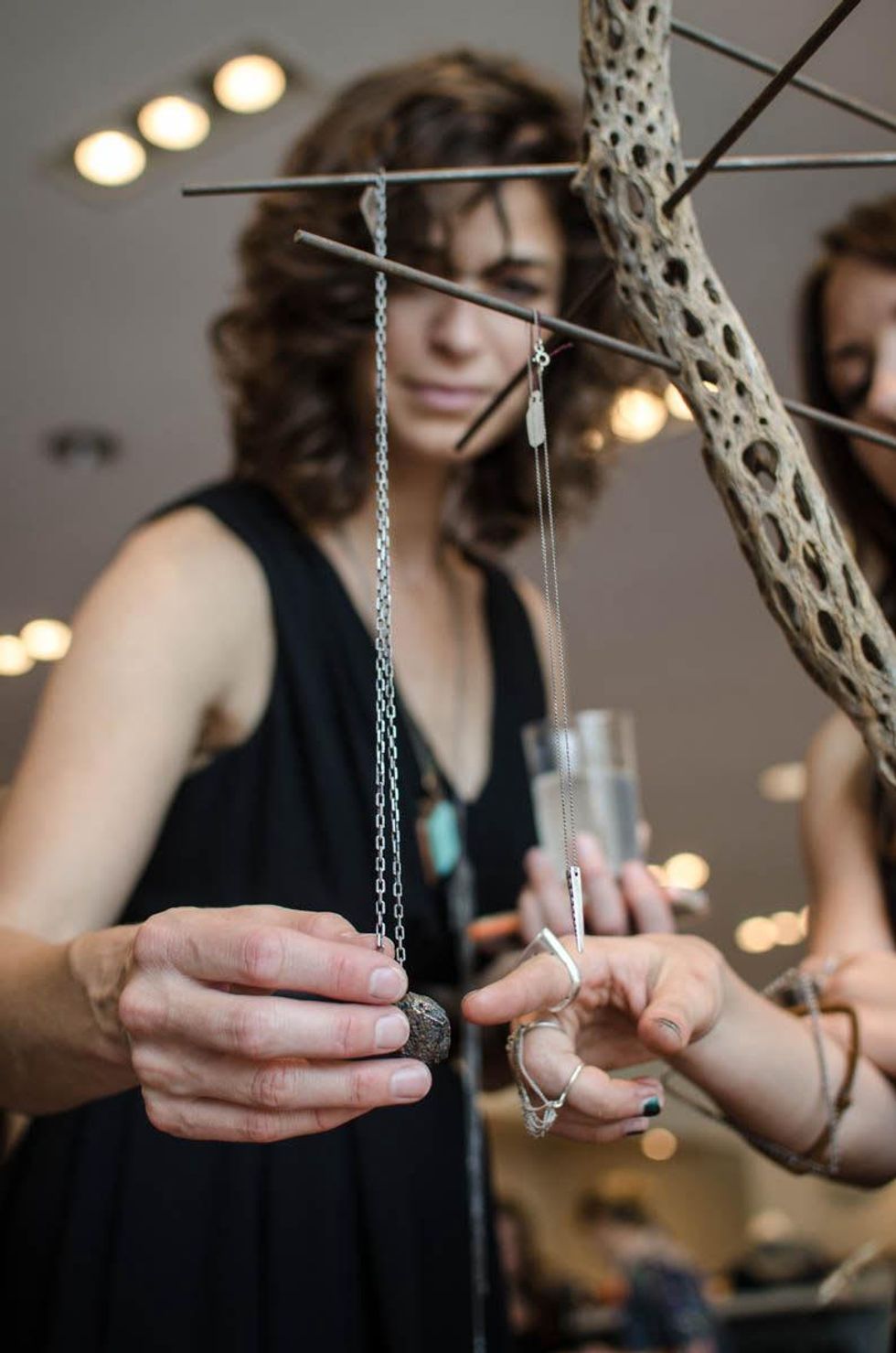 Margot Wolf shows on of her pieces to fellow artist Cambria