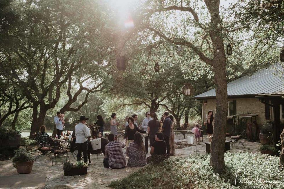 People gather outside at a rehearsal dinner in the Hill Country.