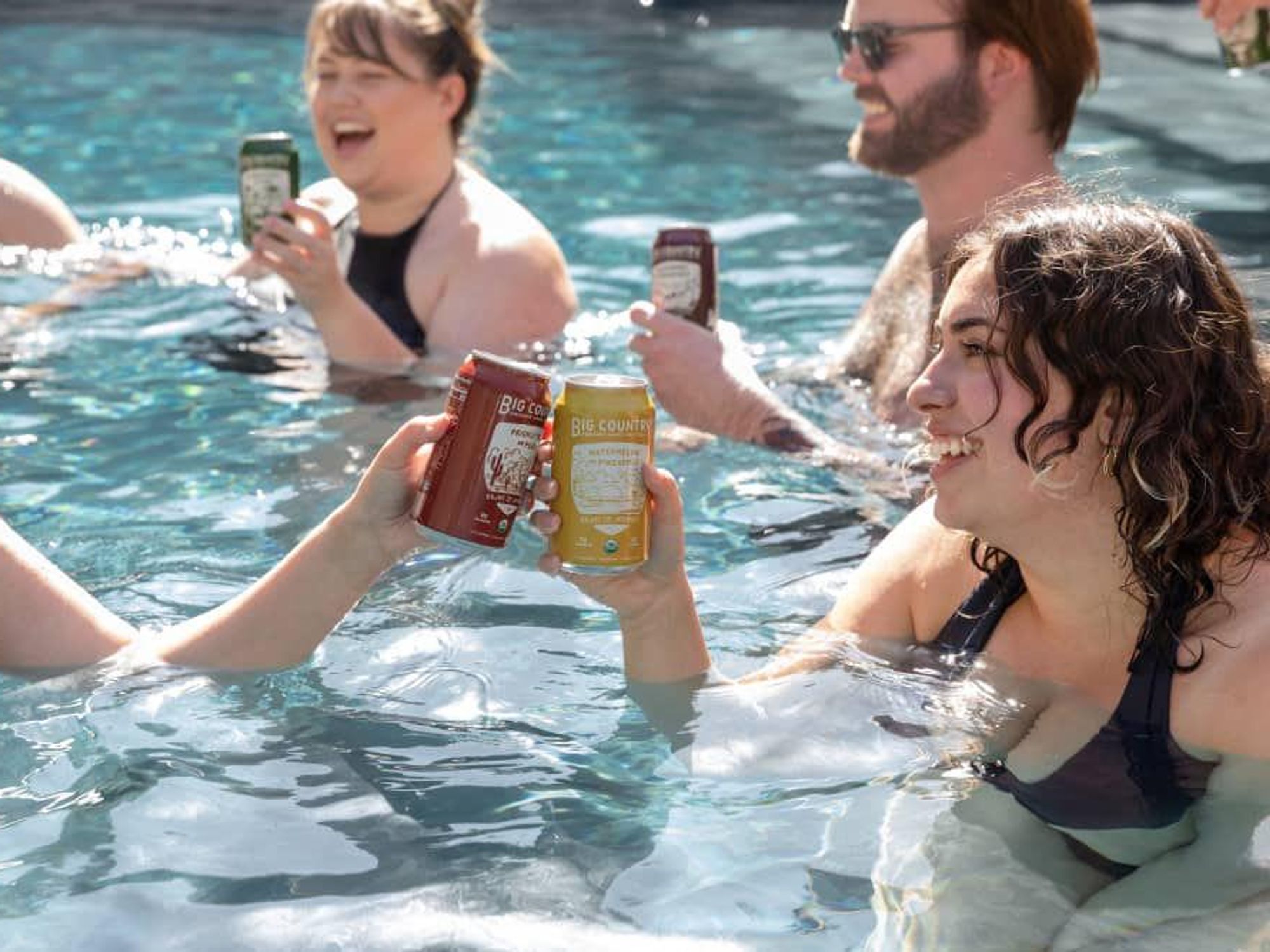 People in a pool drinking Big Country Organic Hard Seltzer