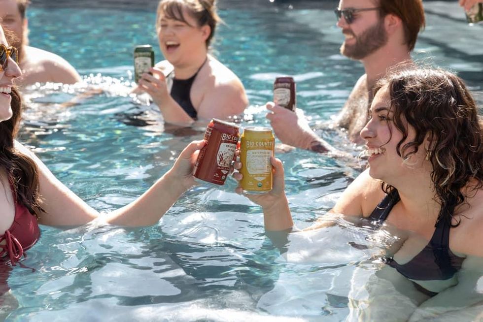 People in a pool drinking Big Country Organic Hard Seltzer