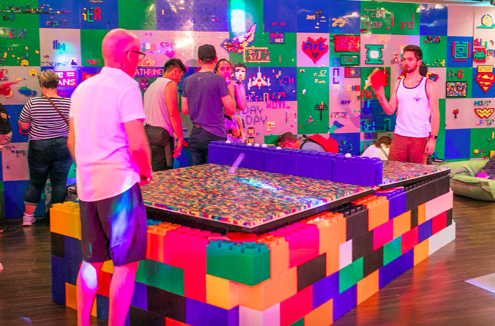 People play ping pong on a table made of over 20,000 Lego bricks