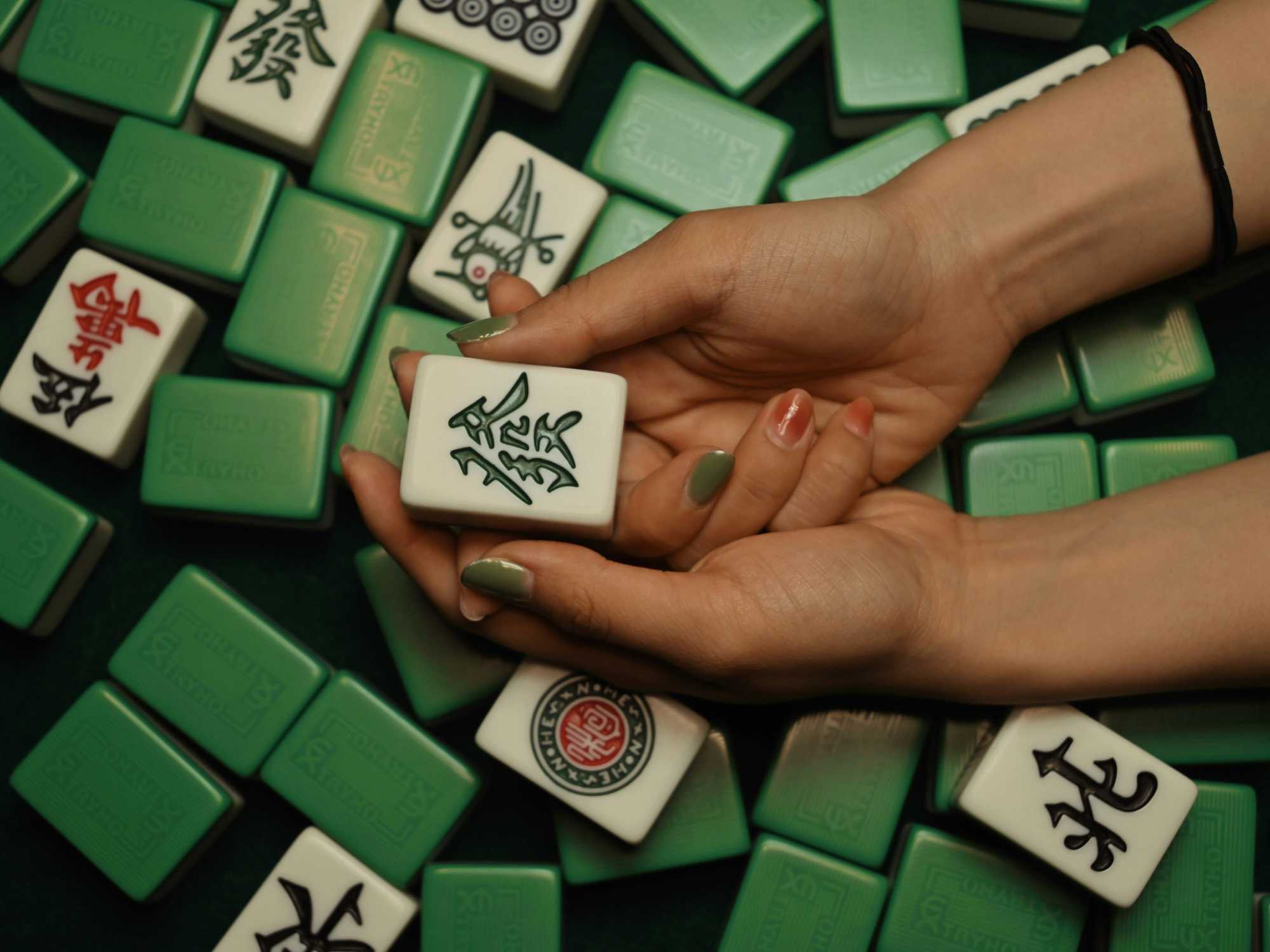 Person holding mahjong tile