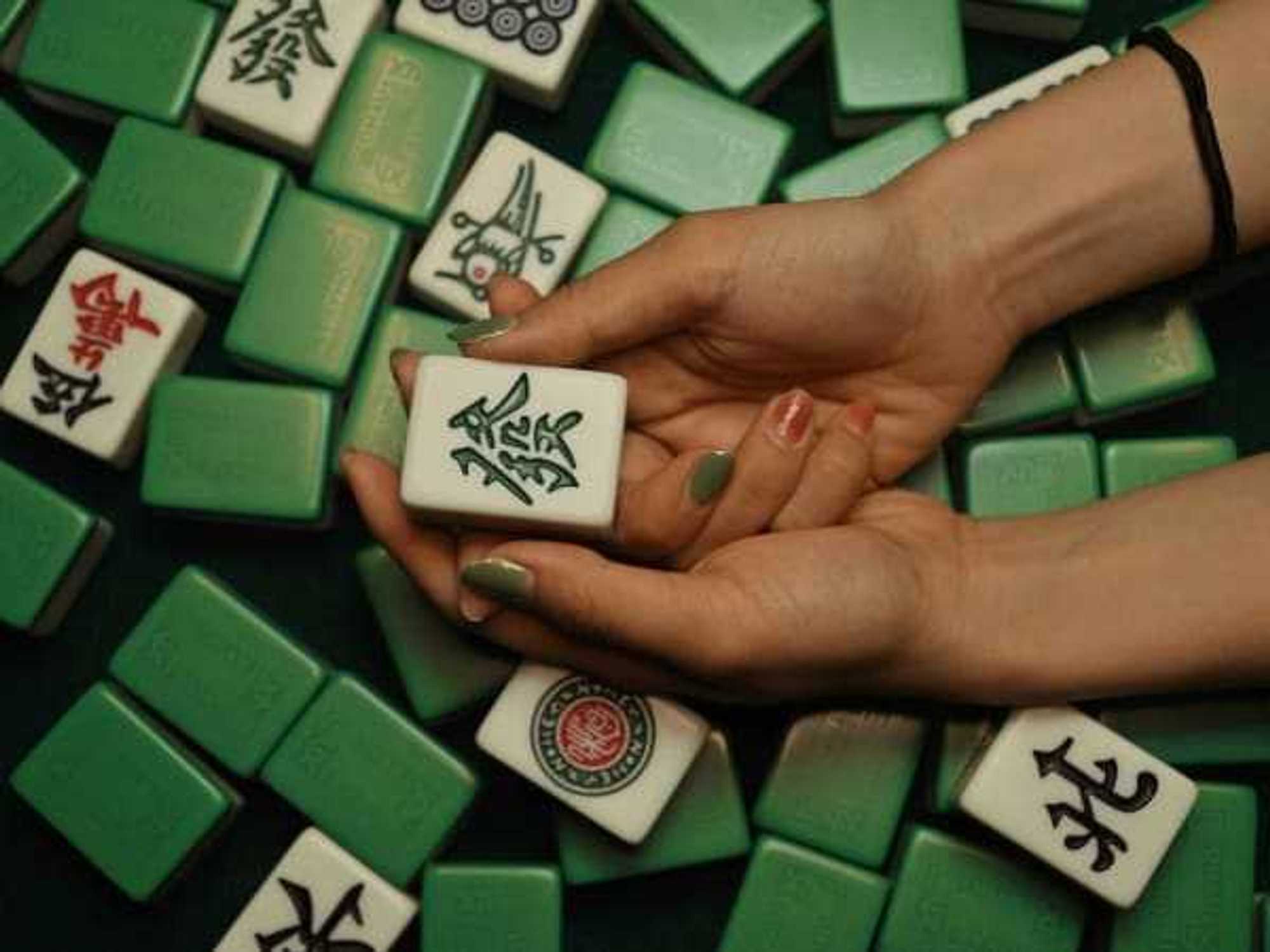 Person holding mahjong tile