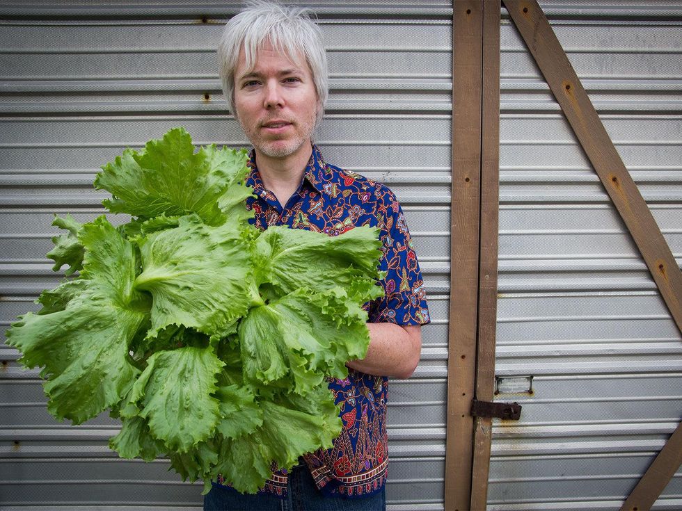 Photo of Marshall Hinsley holding a head of iceberg lettuce