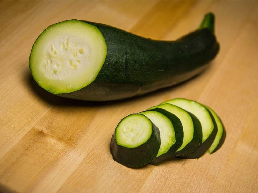 Photo of sliced seedless zucchini on wooden cutting board