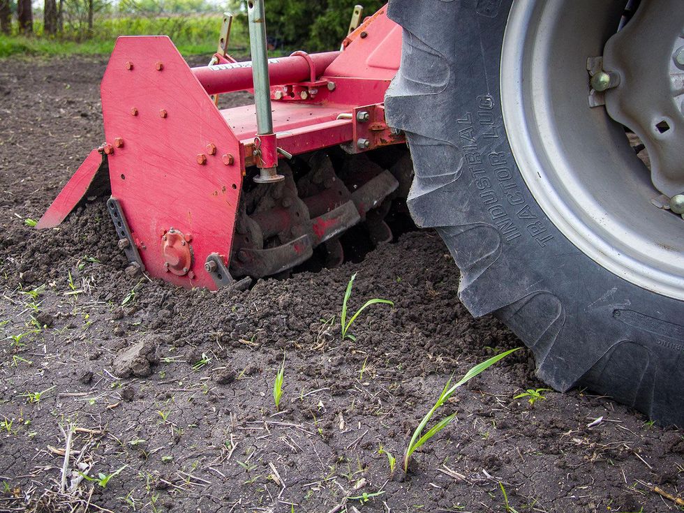 Photo of tractor wheel and tines on a tiller