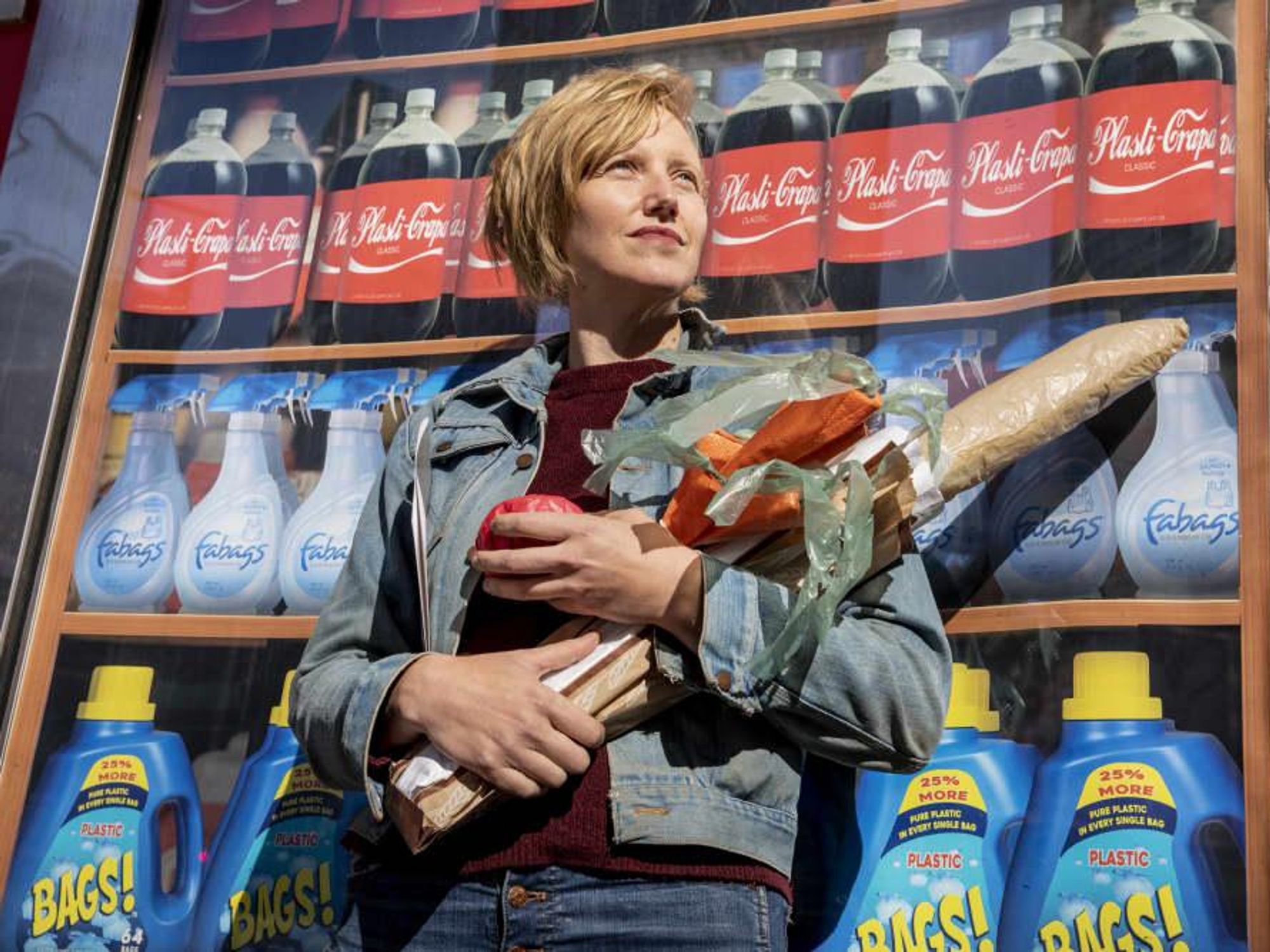 Puppet artist Robin Frohardt holds fake groceries she made out of plastic waste.