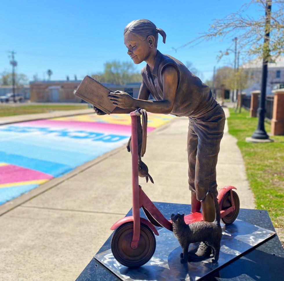 Sculpture of girl on scooter with cat
