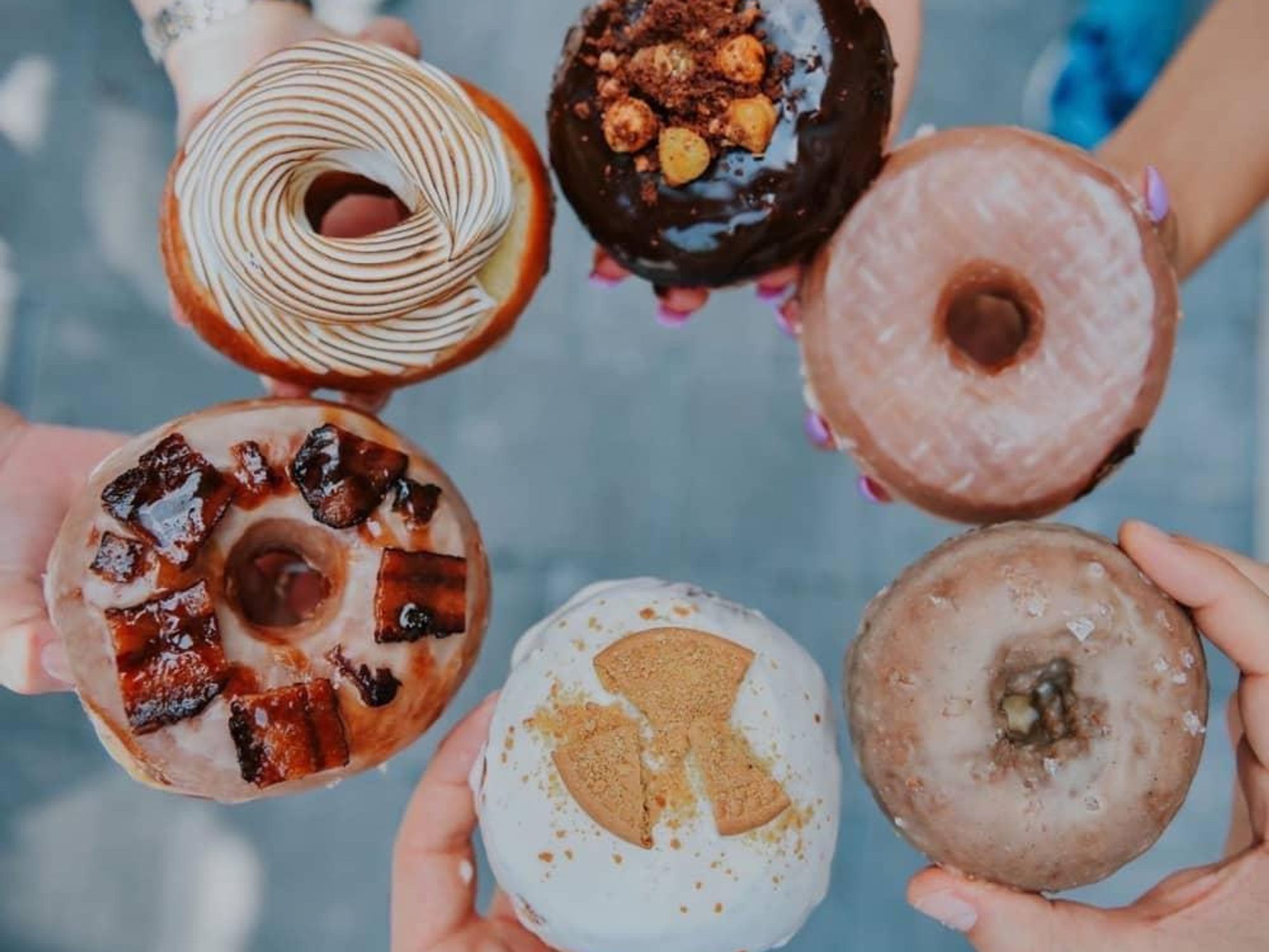 The Salty Donut, group of hands holding doughnuts
