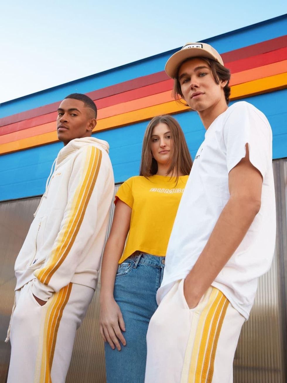 Three models show honey-yellow striped track suits, and Bumble branded t-shirts.