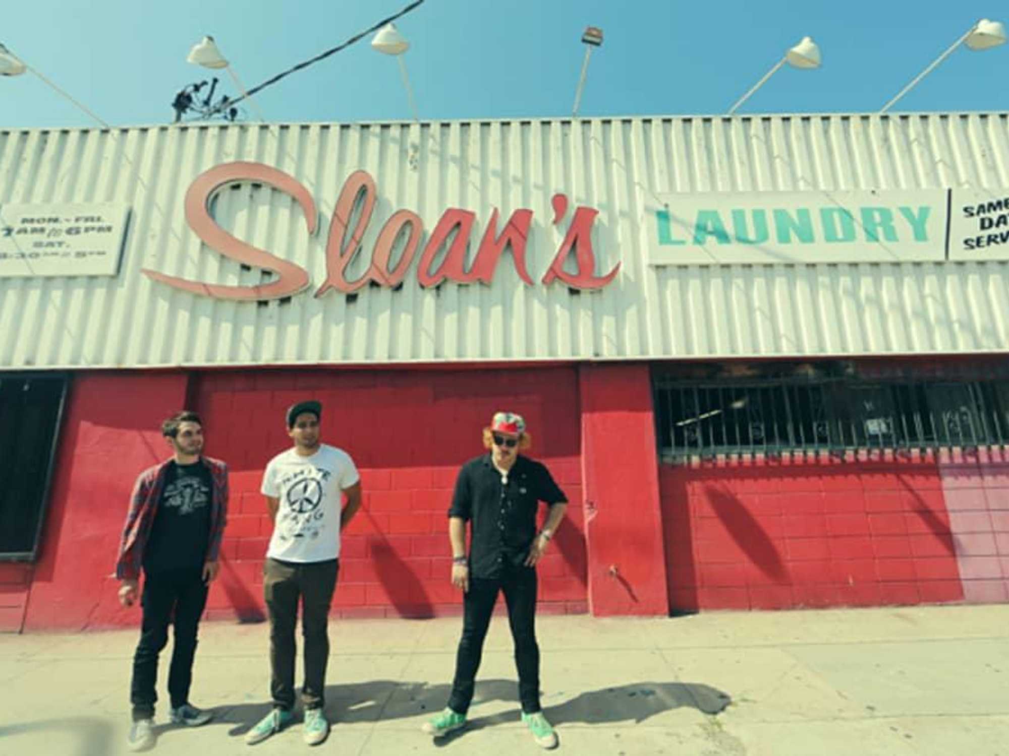 together PANGEA band standing in front of Sloan's Laundry