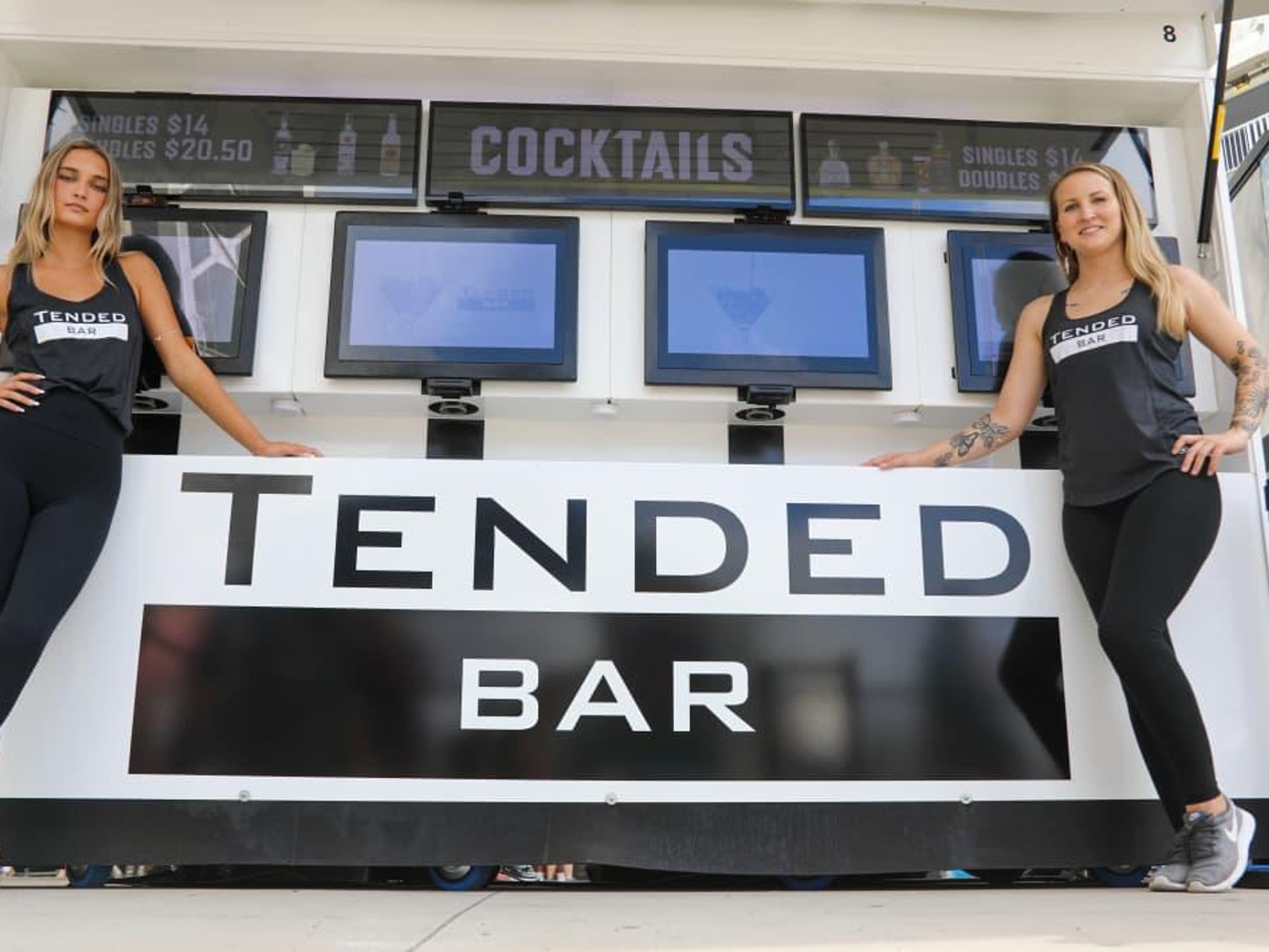 Two people standing next to automated TendedBar coming to Austin.